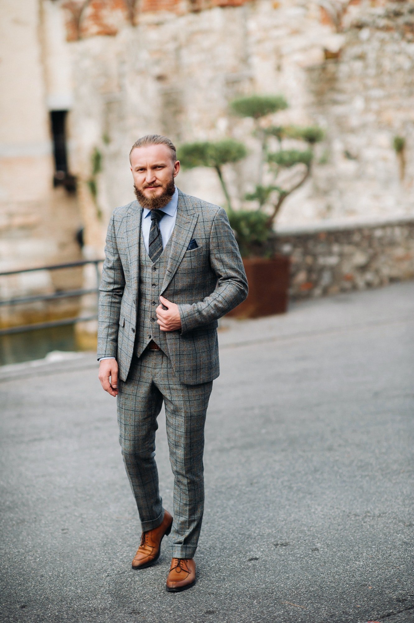 a-man-with-a-beard-in-a-strict-grey-three-piece-suit-with-a-tie-in-the-old-town-of-sirmione-a.jpg
